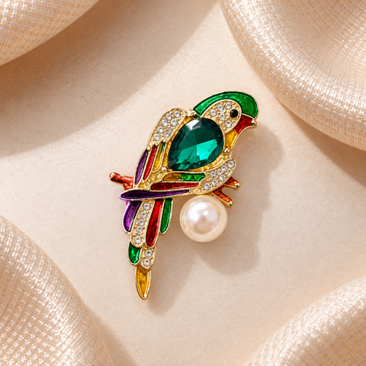 Broche perroquet vert émeraude multicolore avec strass et perle blanche sur fond champagne satiné carré
